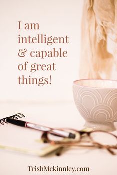 a cup with scissors on the table next to it and a quote that reads, i am intelligentent & capable of great things