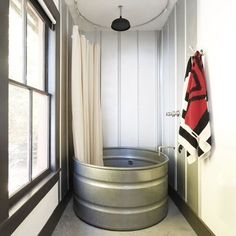 a bathroom with a round tub next to a window and a towel hanging on the wall