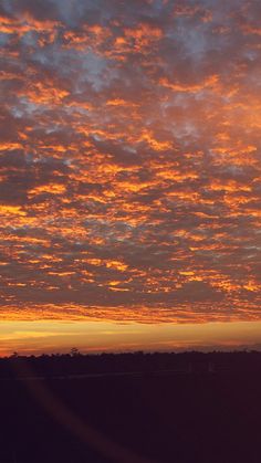 an airplane flying in the sky at sunset