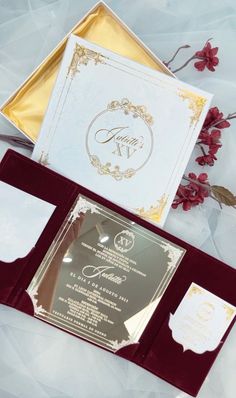 the wedding stationery is set up with gold and red accents, along with matching envelopes