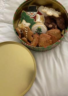 a tin filled with cookies on top of a bed