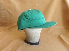 Nice vintage insulated winter hat by K-Products, solid green color with internal adjustable strap. In new condition, original tags attached, never used. Good deep XL fit up to 23.5 inches, can be adjusted with internal hidden snap back strap. Please ask any questions before purchasing, especially concerning fit or condition. All items are vintage and in condition as described. Shipping via USPS unless otherwise agreed upon.  All sales final, no returns - Thank You from Big Weekend! Vintage Winter Baseball Cap For Outdoor, Vintage Green Flat Bill Hat, Retro Green Baseball Cap For Outdoor, Green Military Brimmed Hat, Green Snapback Baseball Cap For Winter, Green Military Hat For Outdoor Activities, Military Green Hat For Outdoor Activities, Green Baseball Cap For Winter Outdoor Activities, Green Winter Baseball Cap For Outdoor