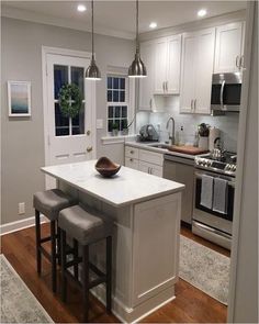 a kitchen with an island and stools in it