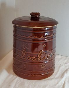 a brown ceramic jar with writing on it