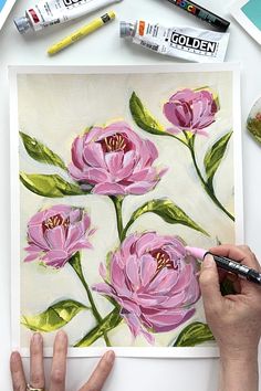 someone is painting flowers on a piece of paper