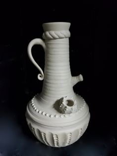 a white vase sitting on top of a table