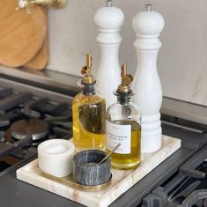 two bottles are sitting on top of a stove burner with soap and toothbrushes