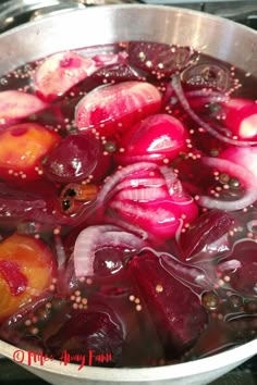 red onions are being cooked in a pot on the stove top, with oil and pepper sprinkles