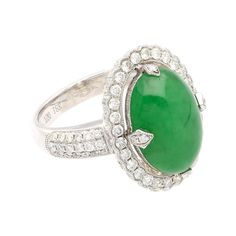 This is part of Chairish’s Fine Jewelry assortment.  Introducing a captivating 18K White Gold Ring, weighing 7.04 grams and adorned with a prong setting for timeless elegance. At the heart of this ring is a vibrant 7.29 carat cabochon-cut "A" grade Jadeite Jade, showcasing a rich green hue. Accentuating the Jade are 126 round-cut Diamonds, totaling 1.19 carats, delicately arranged to enhance the ring's overall brilliance.  Fixed with an intricate milgrain finish around the gemstones.   Item Deta Luxury Jade Rings, Luxury Jade Ring For Formal Occasions, Classic Jade Rings For Formal Occasions, Elegant Green Diamond Ring With Polished Finish, Elegant White Gold Jade Rings, Fine Jewelry Jade Ring For Formal Occasions, Formal Jade Rings Fine Jewelry, Formal Fine Jewelry Jade Rings, Elegant Formal Jade Rings