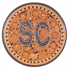 the number 50 carved into an ornate gold and black plate with floral designs on it