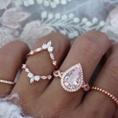 a woman's hand with three rings on it and one is wearing a diamond ring