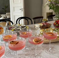 there are many glasses on the table ready to be filled with drinks and desserts