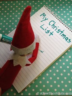 a santa hat on top of a notepad next to a pen