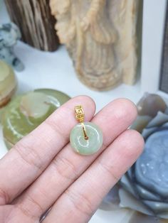 "Ping An Kou Jade are believed to bring good health, peace and safety to the person wearing so they are often worn as pieces of jewelry like pendants, rings, earrings, bracelet charms or kept as amulets. Check out our beautiful, semitranslucent, light honey green Jade \"Ping An Kou\" disc pendant in solid 18 Karat Gold Bail. Type A, natural Burmese Jadeite (non-bleached, non-dyed, non-treated material); glossy, high polished. Bail hole 0.4 cm. Whole pendant weighs 3.2 grams, 1.7 cm width x 2.5 cm height." Spiritual Jade Round Pendant Jewelry, Traditional Yellow Gold Jade Jewelry, Jade Amulet Pendant Jewelry, Jade Pendant Amulet Jewelry, Jade Amulet Jewelry With Round Pendant, Jade Round Pendant For Healing, Jade Healing Pendant Jewelry, Good Luck Amulet Jewelry With Round Pendant, Symbolic Green Gemstone Jewelry