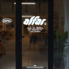 an open window with the words spai written in white on it and two people sitting at a table behind them