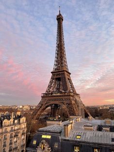 the eiffel tower towering over paris, france at sunset with pink clouds in the sky