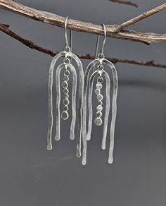 Light catching earrings with plenty of movement, both literally and esthetically. These sterling silver earrings are made with wire and discs, shaped and hammered by hand, soldered with jump rings for lots of constant movement. Lightweight and easy to wear. Delicately brushed finish.  Earrings measure 2 1/4" long from top of ear wire by 5/8" wide.   Surgical steel ear wires protect your pierced holes from irritation. Hammered Wire Jewelry, Hammered Metal Jewelry, Kinetic Earrings, Chrysoprase Necklace, Hammered Jewelry, 18k Gold Necklace, Silver Jewelry Design, Hammered Metal, Ear Wire