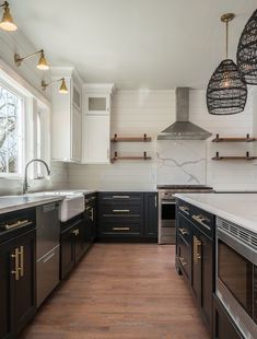 a kitchen with wooden floors and black cabinets