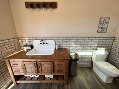 a bathroom with a sink, toilet and trash can