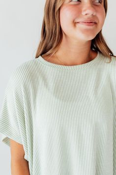 Experience comfort and style with the Journee Top. Its light green color with white stripes adds a touch of freshness, while the dolman sleeves and straight hem provide a relaxed fit. Perfect for any casual outing or lounging at home. Elevate your wardrobe with this versatile and chic top! Fits true to size. Model is wearing a small and is 5'3". Plus model is wearing a 1X and is 5'8". Size Chart Length Bust S 22" 48" M 22" 50" L 23" 48" 1x 24" 52" 2x 24" 54" 3x 25" 56" *All measurements are appr Oversized Ribbed Striped Tops, Oversized Tops With Striped Hem For Spring, Casual Ribbed Tops For Lounging, Spring Oversized Top With Striped Hem, Oversized Spring Top With Striped Hem, Oversized Striped Hem Tops For Spring, White Striped Hem Tops For Spring, White Tops With Striped Hem For Spring, Comfortable Green Summer Tops