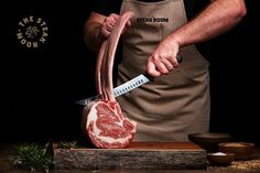 a man in an apron is cutting up a piece of meat with a large knife