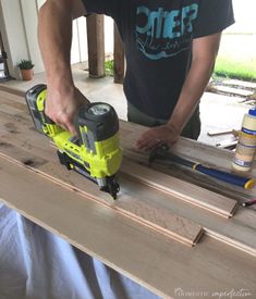 a man using a power drill to cut wood planks with a cordless jig