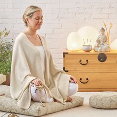 a woman sitting in a meditation position on the floor