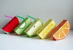 four different types of fruit juice boxes lined up in a row with straws on top