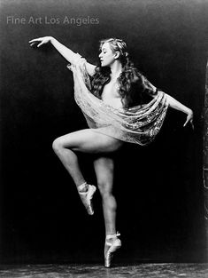 a black and white photo of a ballerina in the air with her arms outstretched