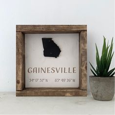 a wooden frame with a map of the state of mississippi in it and a potted plant