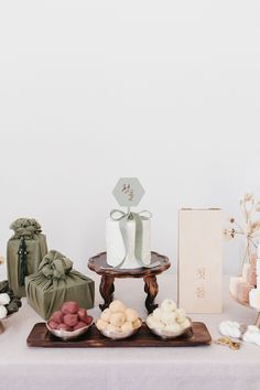 a table topped with lots of different types of cakes and pastries on top of wooden trays