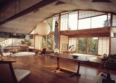 a room with wooden floors and large windows overlooking the trees in the distance is shown