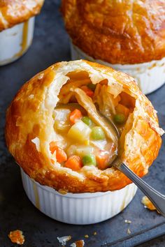 two pot pies filled with different types of food on top of a table next to each other