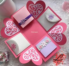 pink and white greeting cards with heart cutouts on them sitting on a lace tablecloth