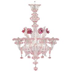 a pink chandelier hanging from the ceiling with flowers on it's sides