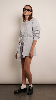 The Sierra shirt dress is effortlessly chic. It's made from crisp cotton-poplin with a loosely draped top and close-fitting mini skirt. Unbutton the collar to create a more relaxed look. Dress is designed to look like a deconstructed shirt worn back to front. Detailed with buttons along the reverse, it's cut from cotton-poplin and has a loose shape tempered by ties at the waist meant to resemble a second pair of sleeves. 100% Cotton Deconstructed Shirt, Draped Top, Holiday Party Outfit, Simon Miller, Black Shirt Dress, Engineered Garments, Blazer Dress, Blue Jacket, Cotton Poplin