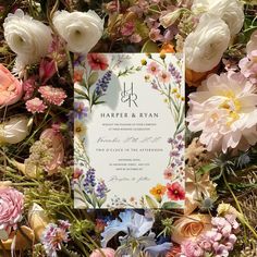 a wedding card surrounded by flowers and greenery