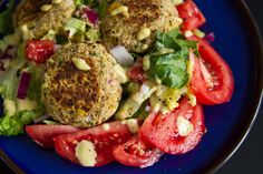 a blue plate topped with meat patties and salad on top of lettuce