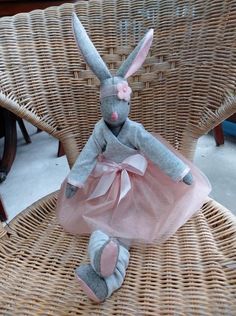 a stuffed rabbit sitting on top of a wicker chair