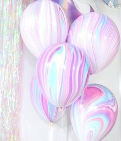 there are balloons that look like marbles in the air and have been painted with pastel colors