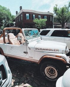 an old jeep with the word scrambler on it parked in front of other cars