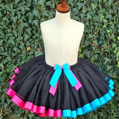 a mannequin wearing a black skirt with pink, blue and green ribbons on it