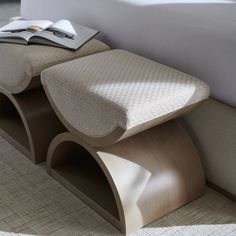 a close up of a bed with a book on top of the headboard and foot rest