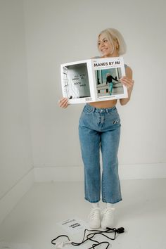 a woman is holding up a book in front of her face and posing for the camera