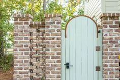 an open door is in between two brick pillars on the side of a house,