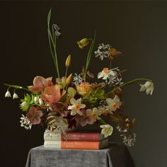 a bouquet of flowers sitting on top of two books