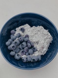 a blue bowl filled with oatmeal and blueberries