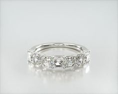 a white gold wedding ring with five stones on the side and three rows of diamonds in the middle