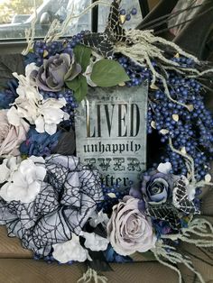 a car decorated with flowers, leaves and a sign that says lived unhapply