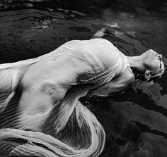 black and white photograph of a woman floating in water